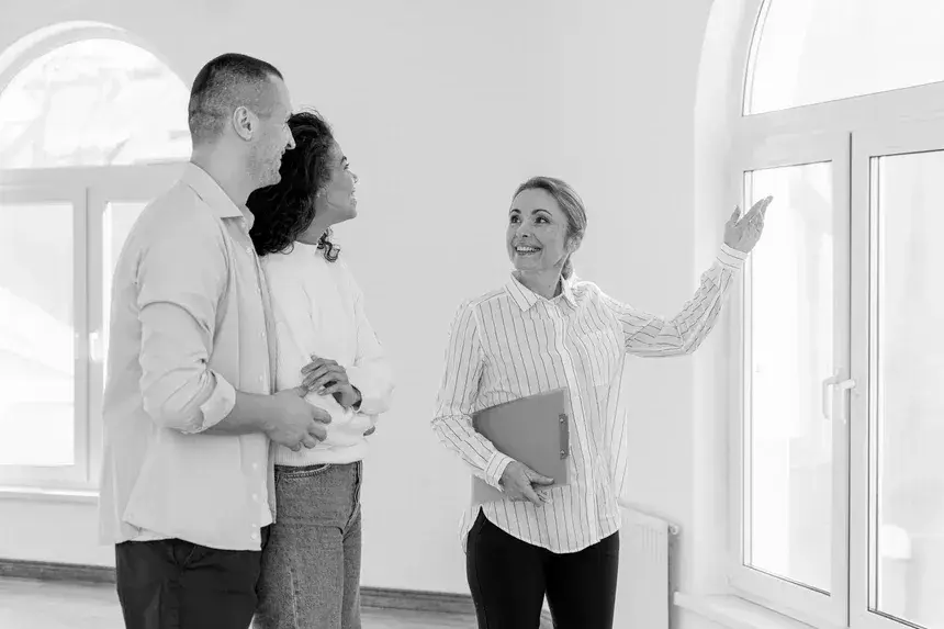 smiley-female-realtor-showing-empty-house-young-couple-modified